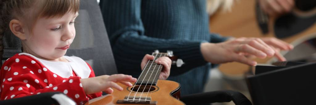 Mädchen probiert Ukulele zu spielen