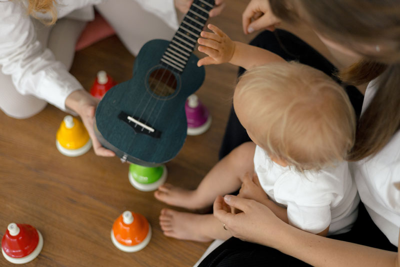Ein kleines Kind versucht ein Ukulele zu spielen