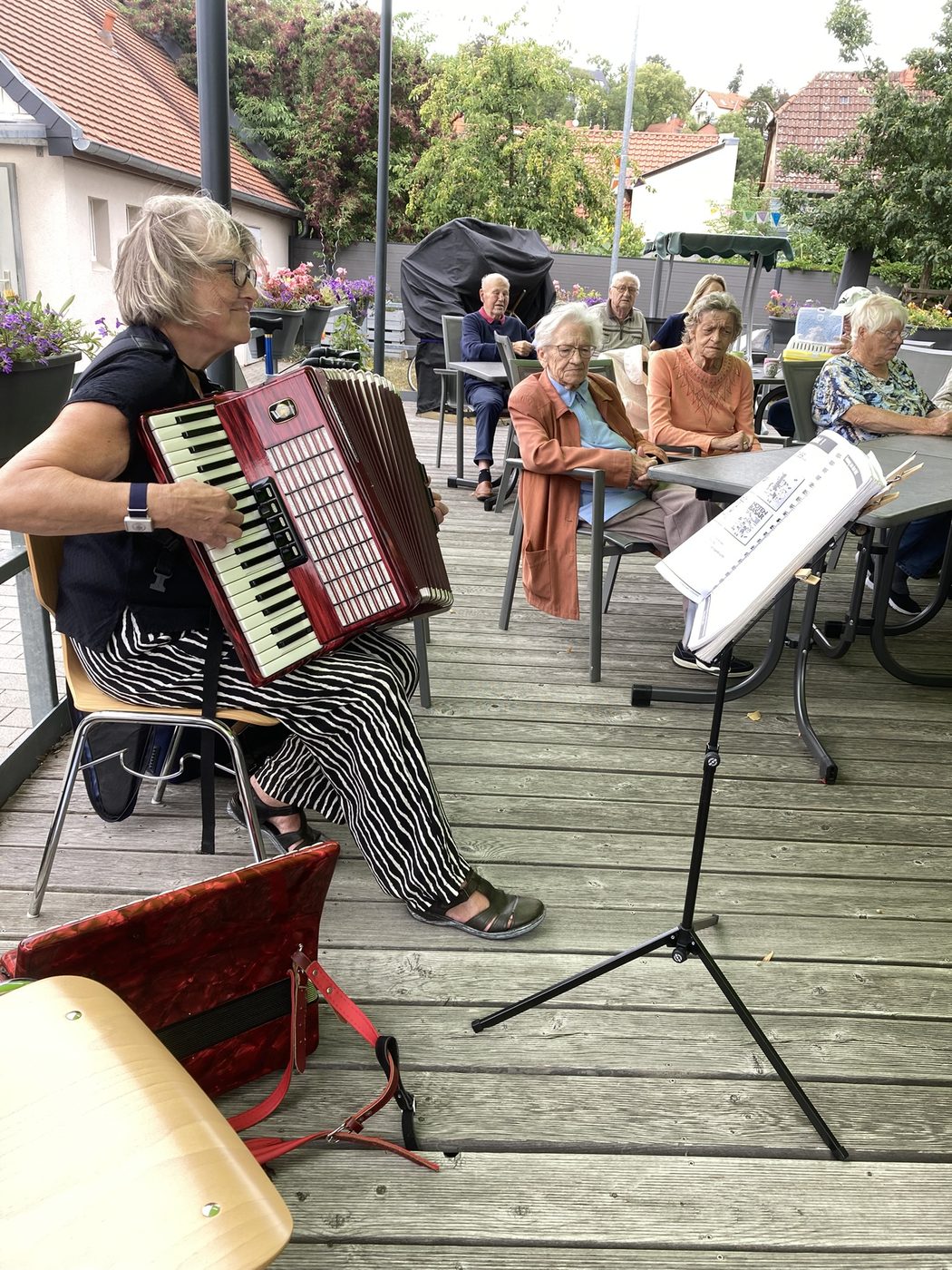 Erwachsene Schülerin der Musikschule Erfurt spielt Akkordeon beim Sommerkonzert in der Tagespflege Hochheim