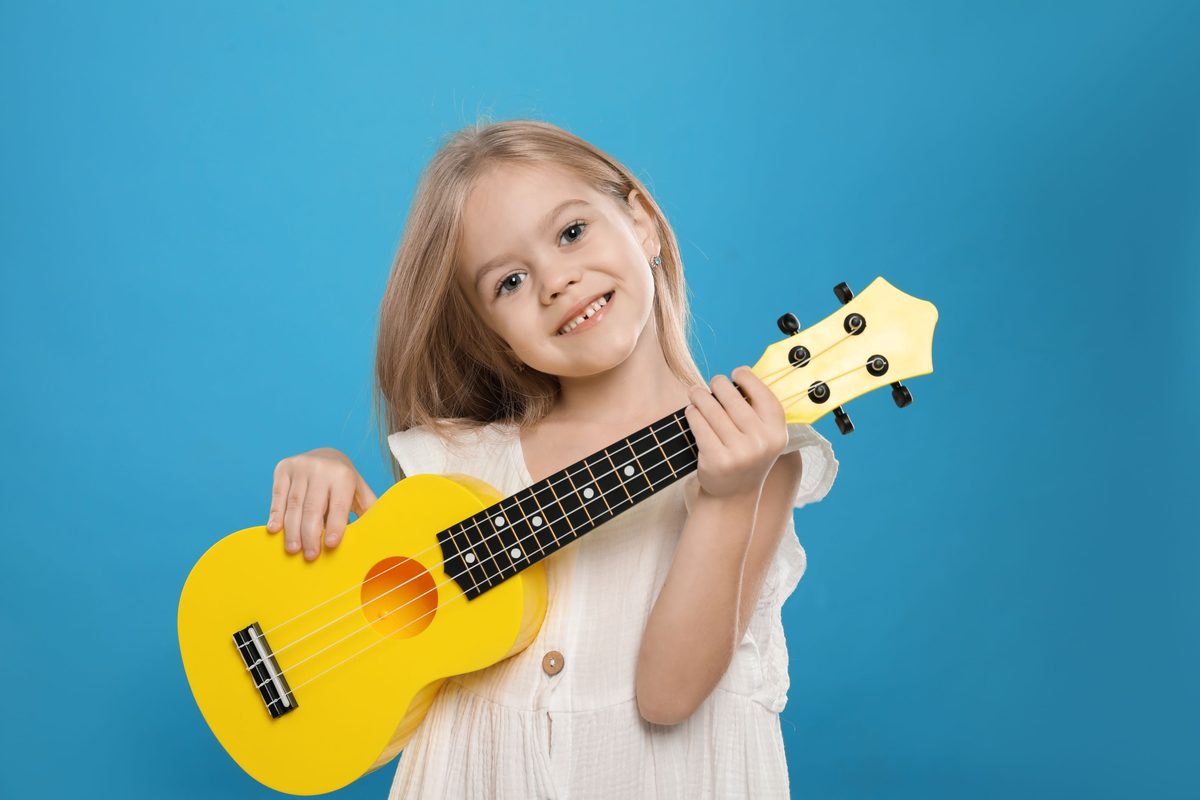 Fröhliches Mädchen spielt Ukulele im Musikkurs an der School International Erfurt