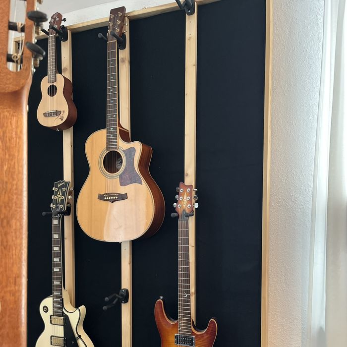Gitarren, E-Gitarren und Ukulele an der Wand der Musikschule