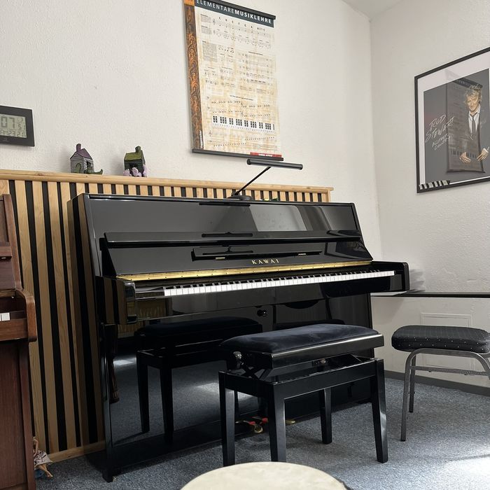 Heller Unterrichtsraum mit Klavier und Trommeln